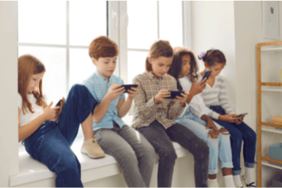 5 kids playing on their phones against the window