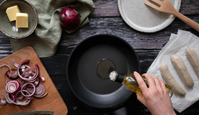 Overhead view of someone pouring oil into a skillet